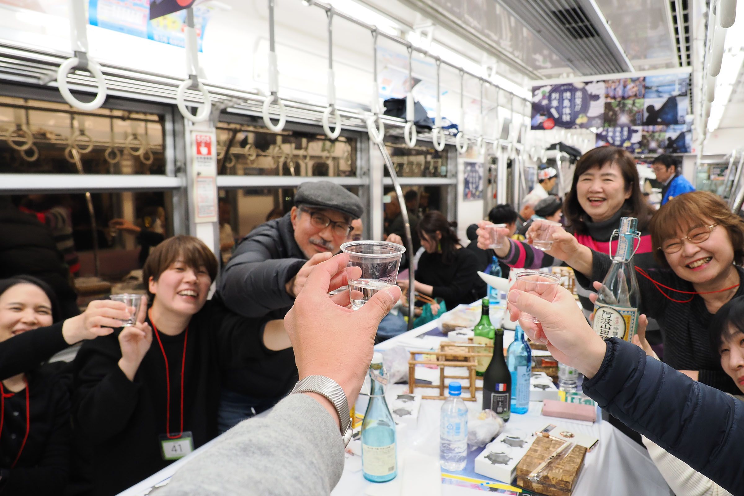 車内で乾杯。日本酒好きな鉄道ファンにはたまらない一瞬だろう＝2023年11月（撮影：伊原薫）