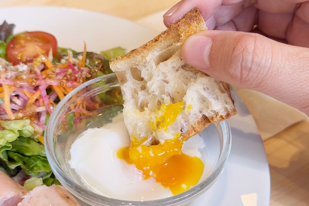 ポーチドエッグの黄身に、バケットをダンク。パンをまろやかに味変させてくれるディップに早変わり（筆者撮影）