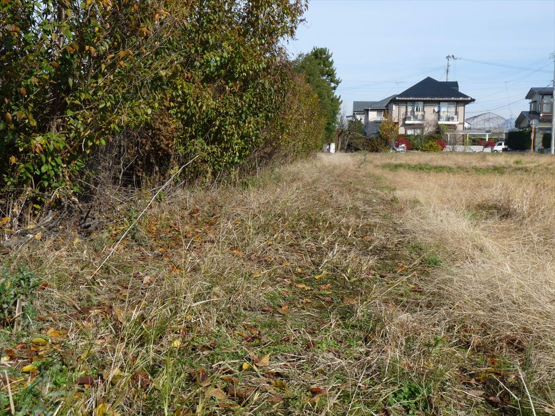 滝山～飯田：写真中央の奥（山形方面）から手前（上ノ山方面）に向けて蔵王高速電鉄の線路敷地が延びる。敷地は周辺の田畑との区別がつきにくい（筆者撮影）