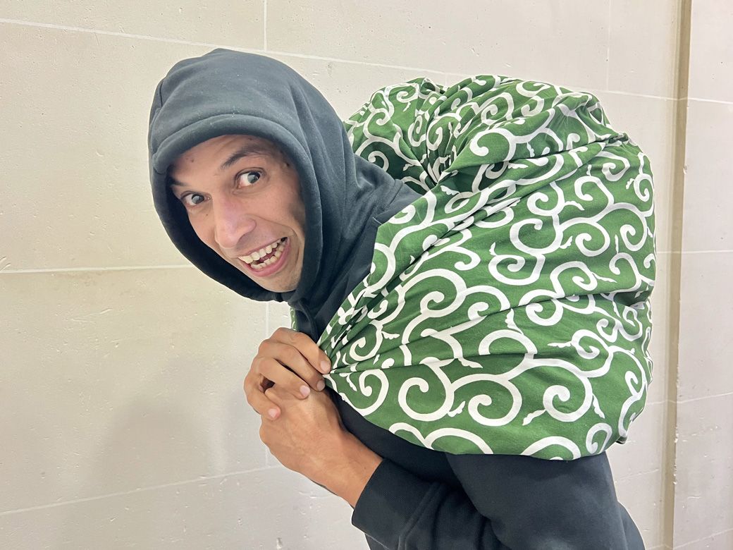 唐草模様の風呂敷を背負うカリムさん。なかなか様になっている。大笑いしすぎて、真面目な写真をすっかり撮り忘れてしまった筆者であった（筆者撮影）