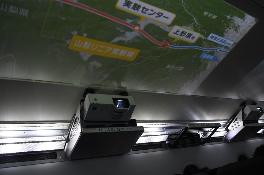 M10の座席上荷棚付近には天井に映像を映し出すプロジェクターが並ぶ（記者撮影）