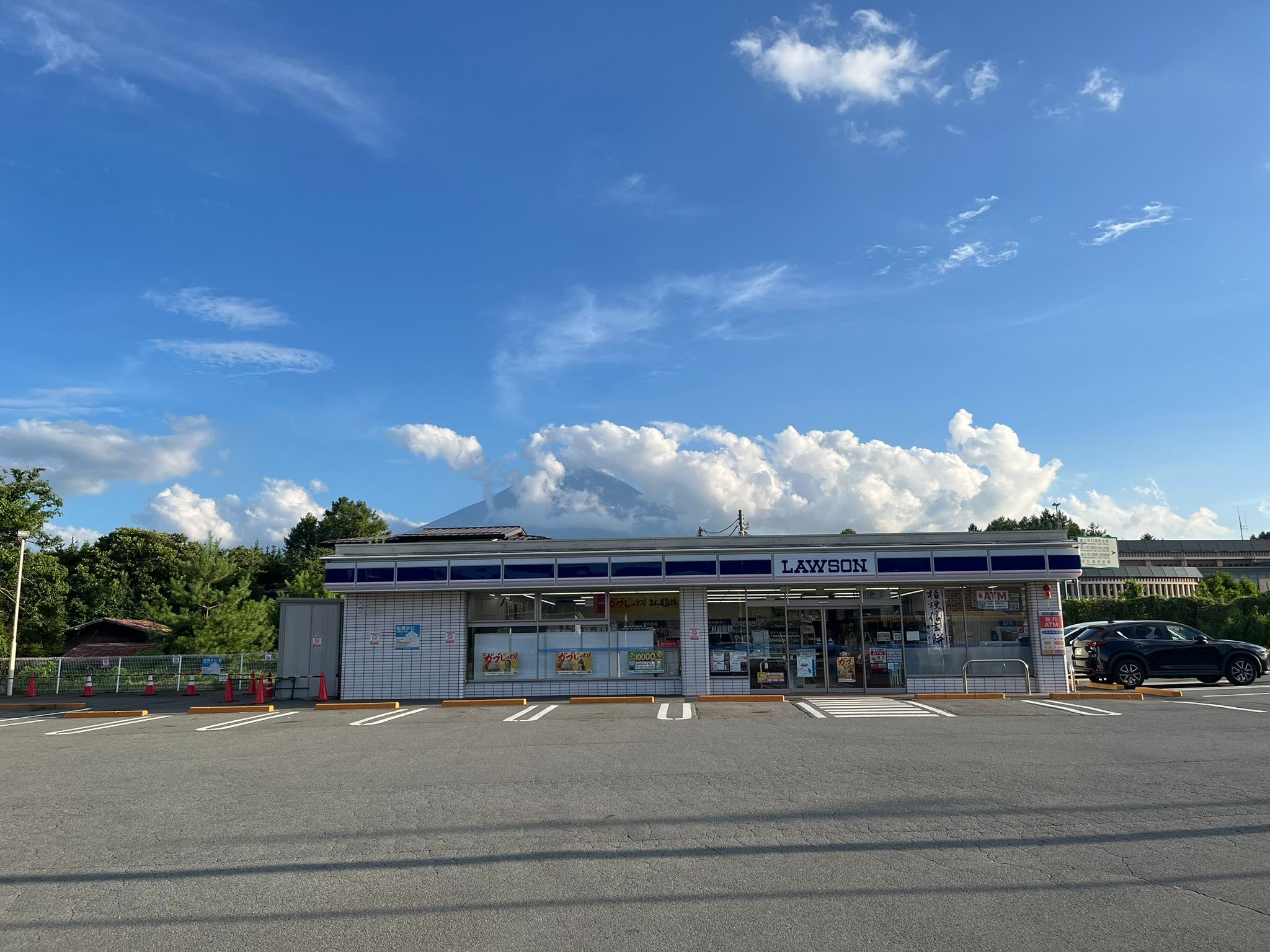 筆者が訪れたときはあいにく雲がかかってしまっていましたが、コンビニの屋根越しに富士山が見えます（筆者撮影）