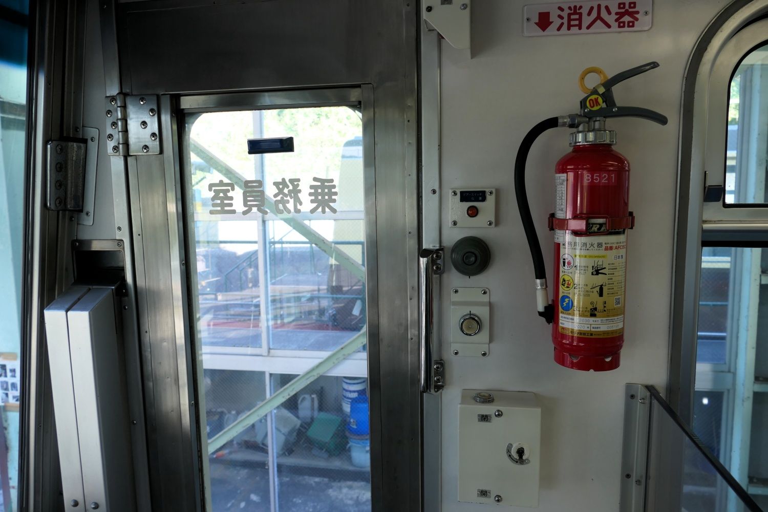 乗務員室の扉とその周辺。消火器などを備える（記者撮影）