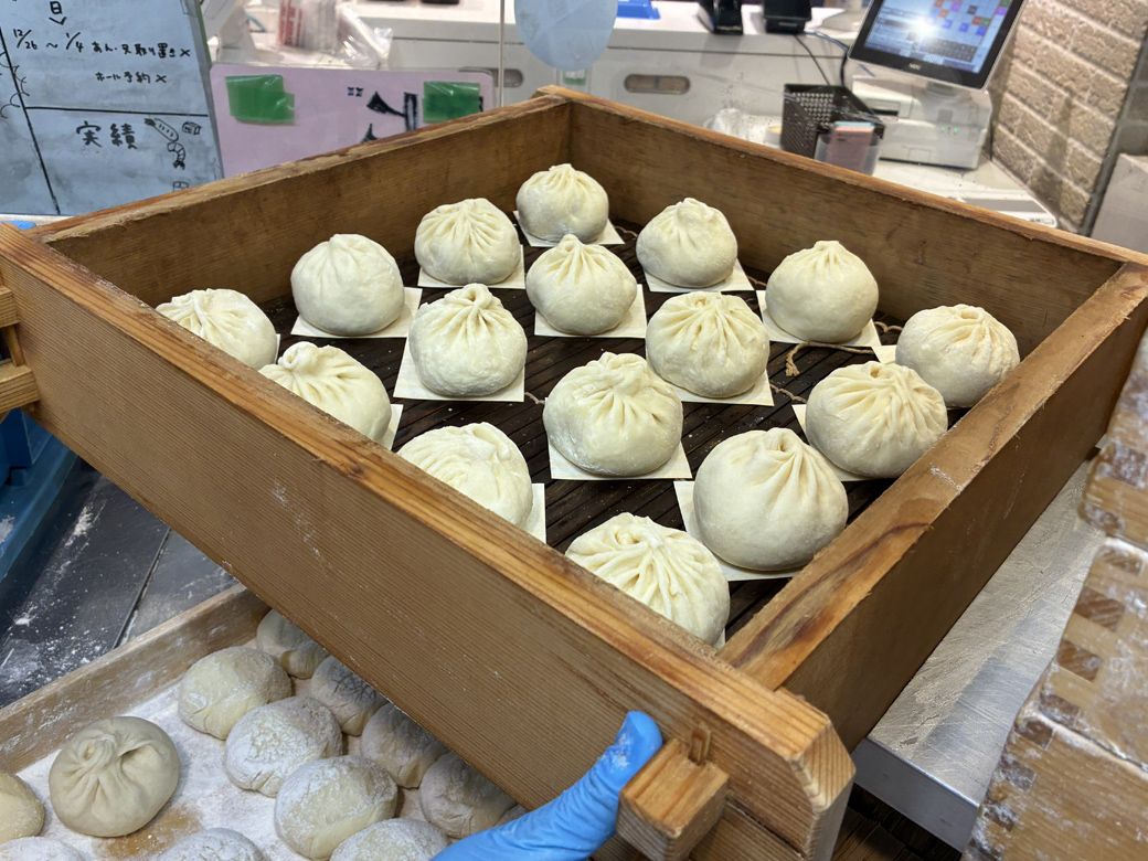 特製の生地で包まれた、蒸し上げる前の豚まんたち（筆者撮影）