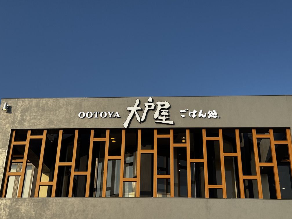 ロゴのアップ。青空にグレーと白地が映える（編集部撮影）