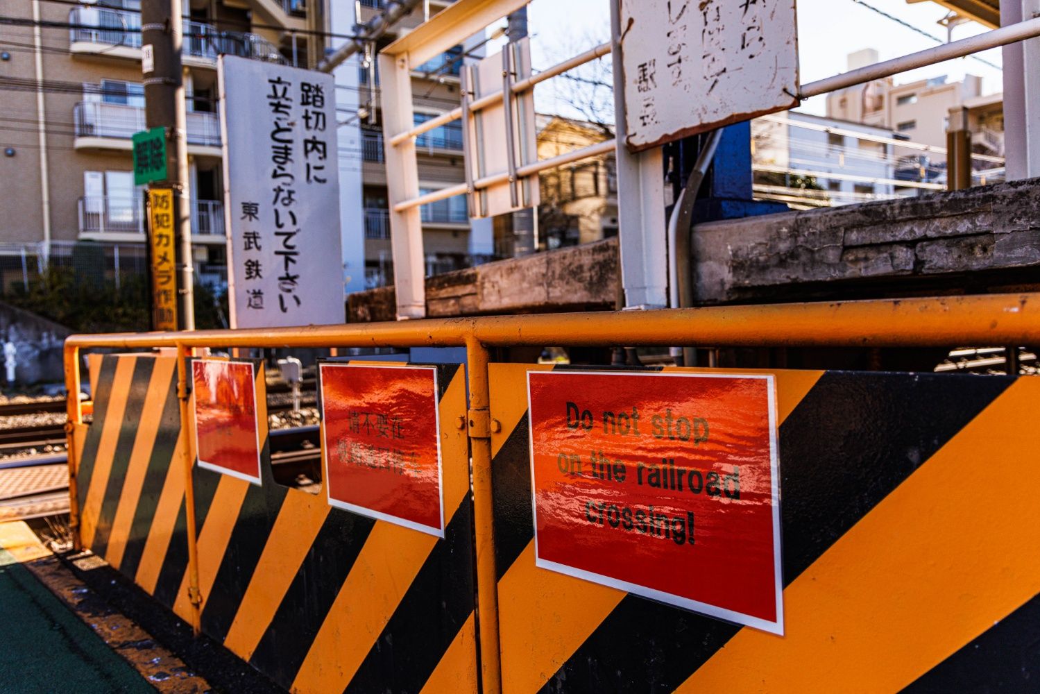 踏切道には外国語での注意書き。北池袋駅周辺には外国人向けの民泊が多いという（撮影：鼠入昌史）