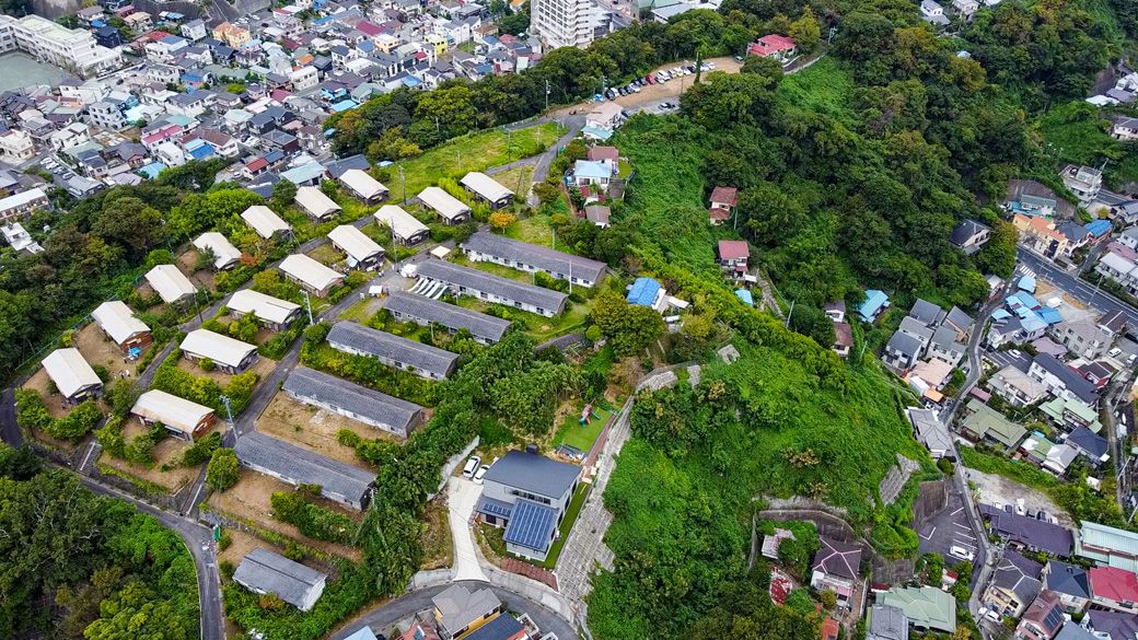 現地空撮。周囲から少し高くなったところに住棟が並んでおり、他の住宅とはちょっと違う存在であることが分かる（写真：エンジョイワークス提供）