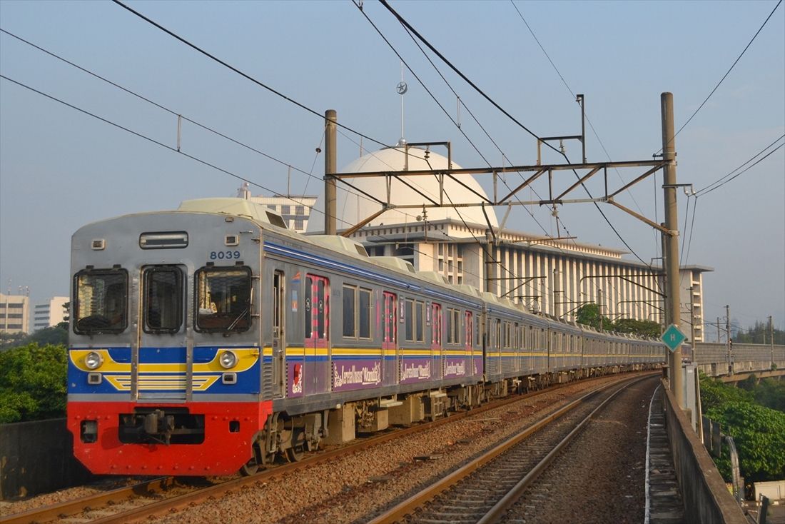 ジャカルタのアイコンでもあるイスティクラルモスクをバックに高架線を快走する、元東急8000系の8039編成（筆者撮影）