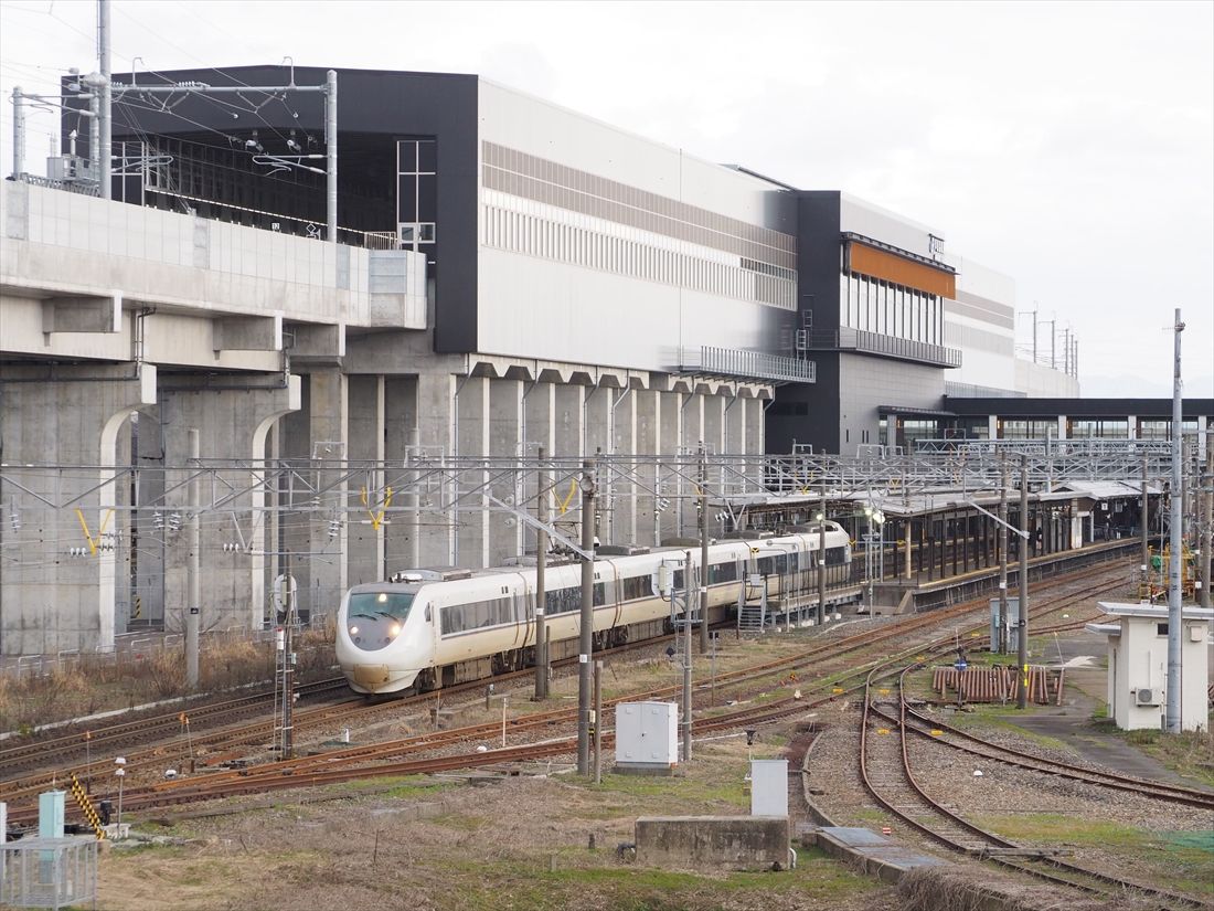 新幹線の芦原温泉駅をバックに走る在来線特急「しらさぎ」（記者撮影）