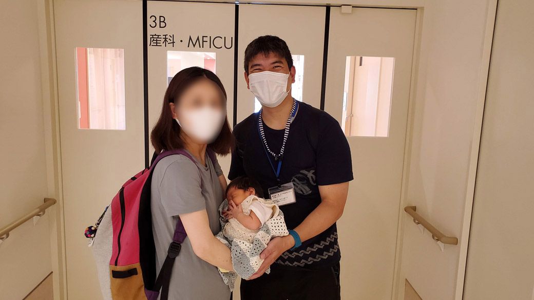 出産後、退院時の写真。コロナ禍でもあり、坂田さん自身は背後の「産科・MFICU」（入院病棟）には入れなかった（写真：坂田さん）