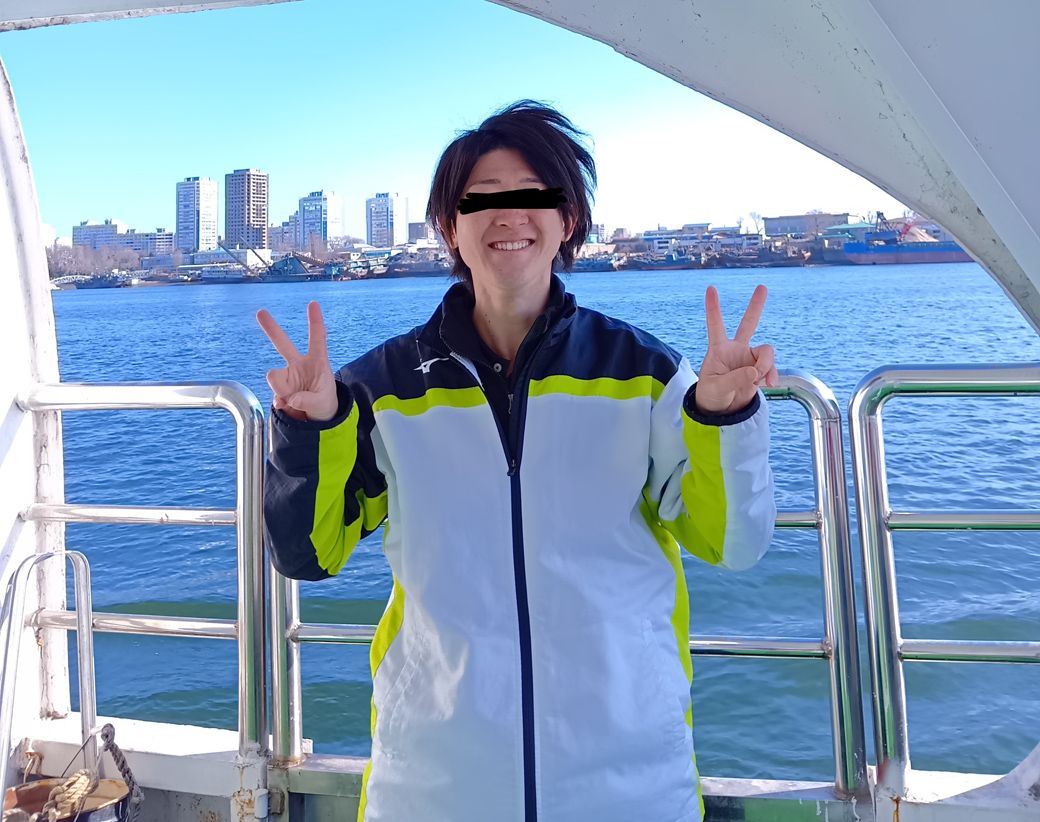 今回の1人旅もいつも通り、YONEXとMIZUNOの服を選んだ。なお奥に見えているのは北朝鮮の街並み（写真：筆者撮影）